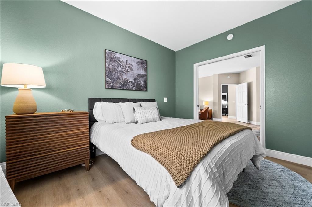 6080 Pinnacle Lane, Unit 1701 Naples, FL 34110 - Photo 29 of 39 a bedroom with bed and wooden floor