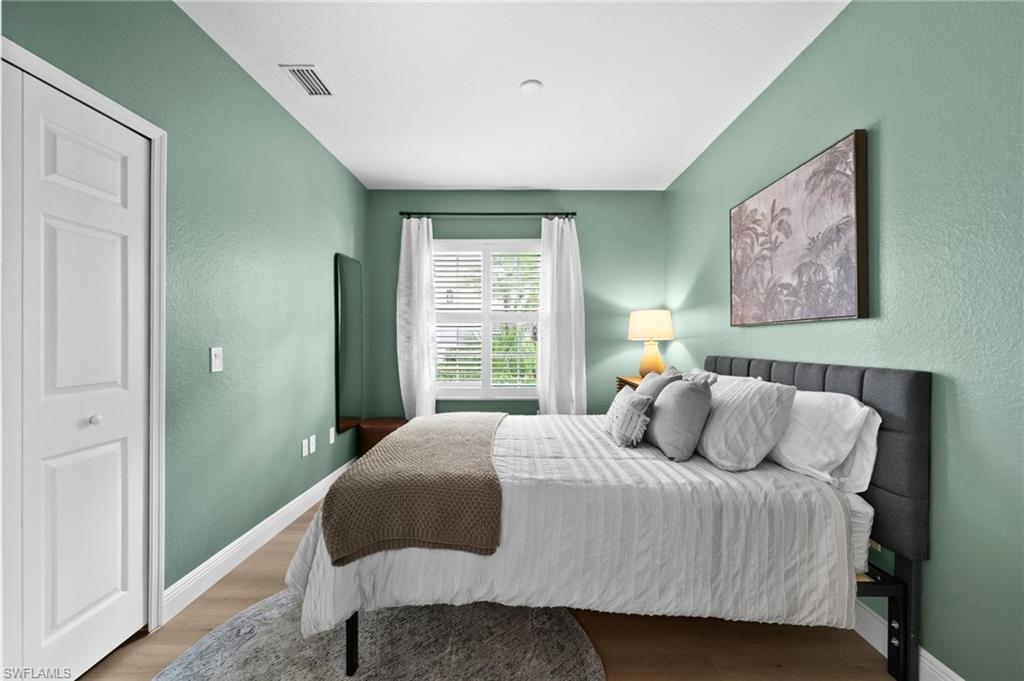6080 Pinnacle Lane, Unit 1701 Naples, FL 34110 - Photo 30 of 39 a bedroom with a bed and a painting on the wall