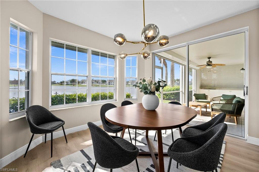 6080 Pinnacle Lane, Unit 1701 Naples, FL 34110 - Photo 10 of 39 a view of a dining room with furniture window and wooden floor