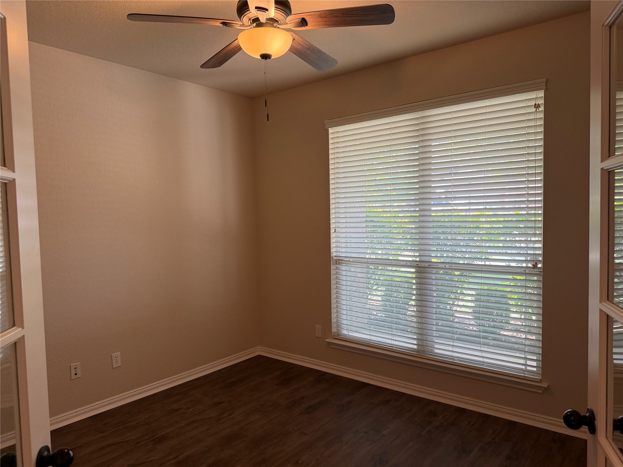 3021 Grand Mission Way Pflugerville, TX 78660 - Photo 7 of 31 A well-lit room offers ample natural light and practical wood flooring, perfect for a home office.