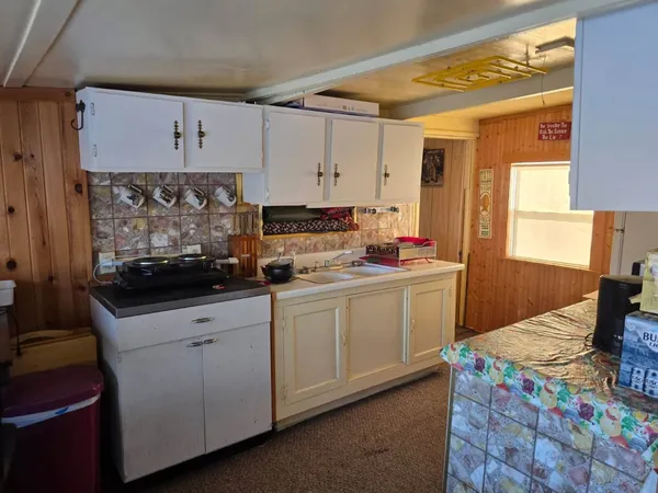 a kitchen with granite countertop a sink stove and cabinets