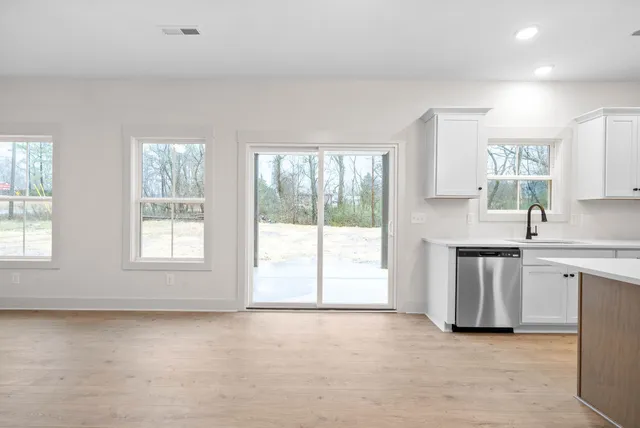 a kitchen with stainless steel appliances granite countertop a stove a sink and a large window