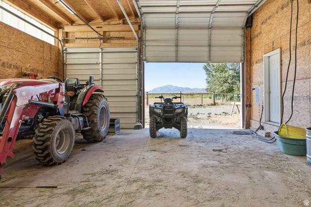 1634 West Arimo Road Arimo, ID 83214 - Photo 49 of 89 Spacious garage interior featuring concrete flooring, exposed wood framing, and two large overhead doors