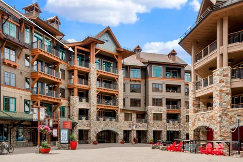a front view of building with lot of cars and trees