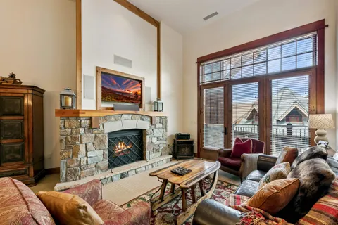 a living room with furniture a fireplace and a floor to ceiling window