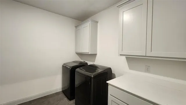 an empty room with windows and chandelier fan