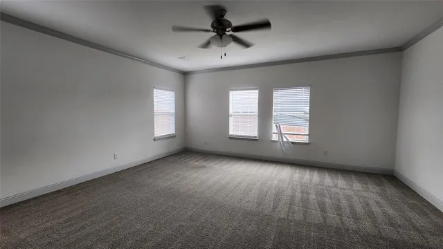 an empty room with a window and a ceiling fan