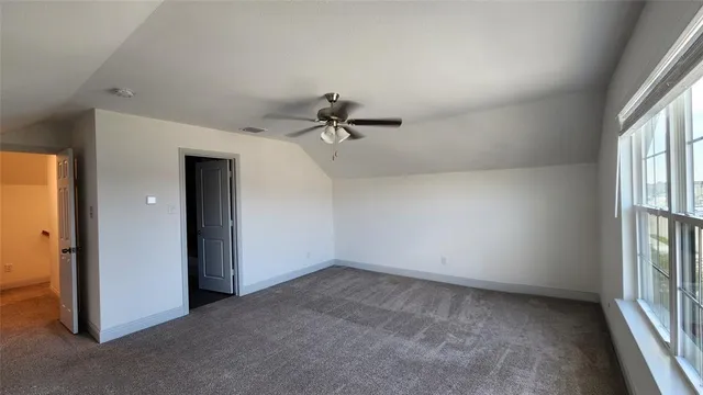 an empty room with windows and fan