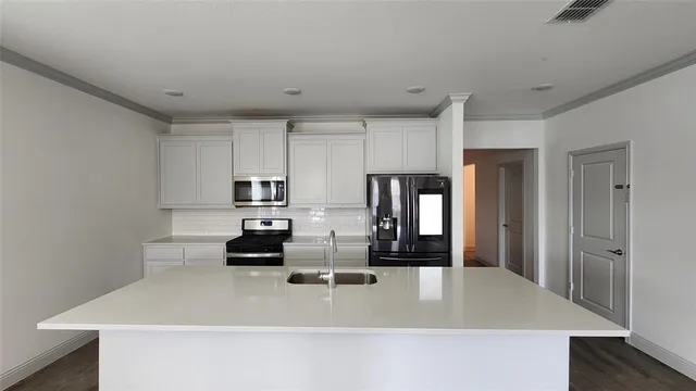 a kitchen with stainless steel appliances granite countertop a refrigerator a stove and a sink