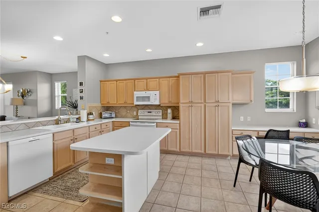 a kitchen with a sink a counter top space cabinets and stainless steel appliances