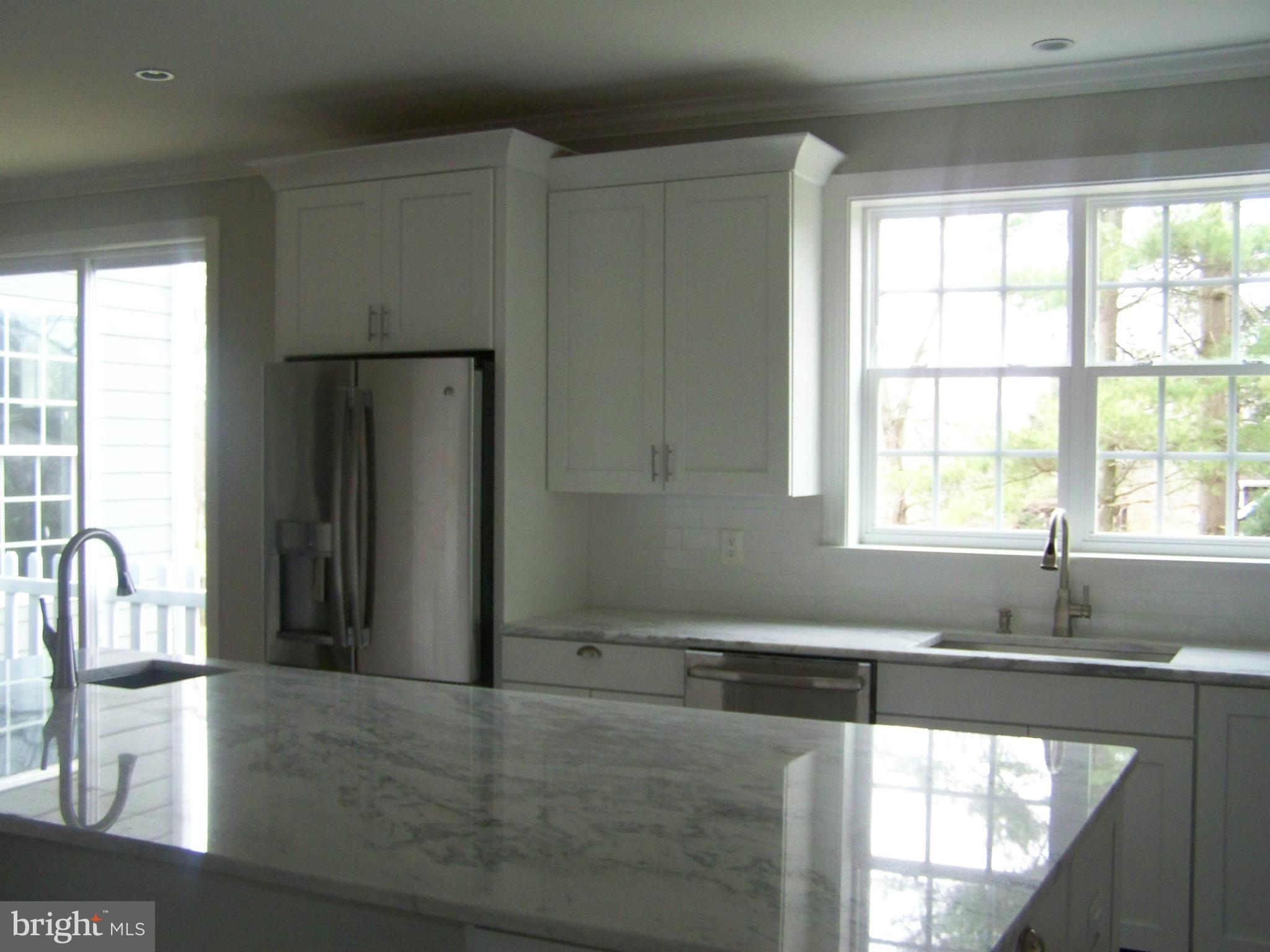 4324 Holly Ridge Road Rockville, MD 20853 - Photo 7 of 16 a kitchen with stainless steel appliances kitchen island granite countertop a refrigerator and a sink