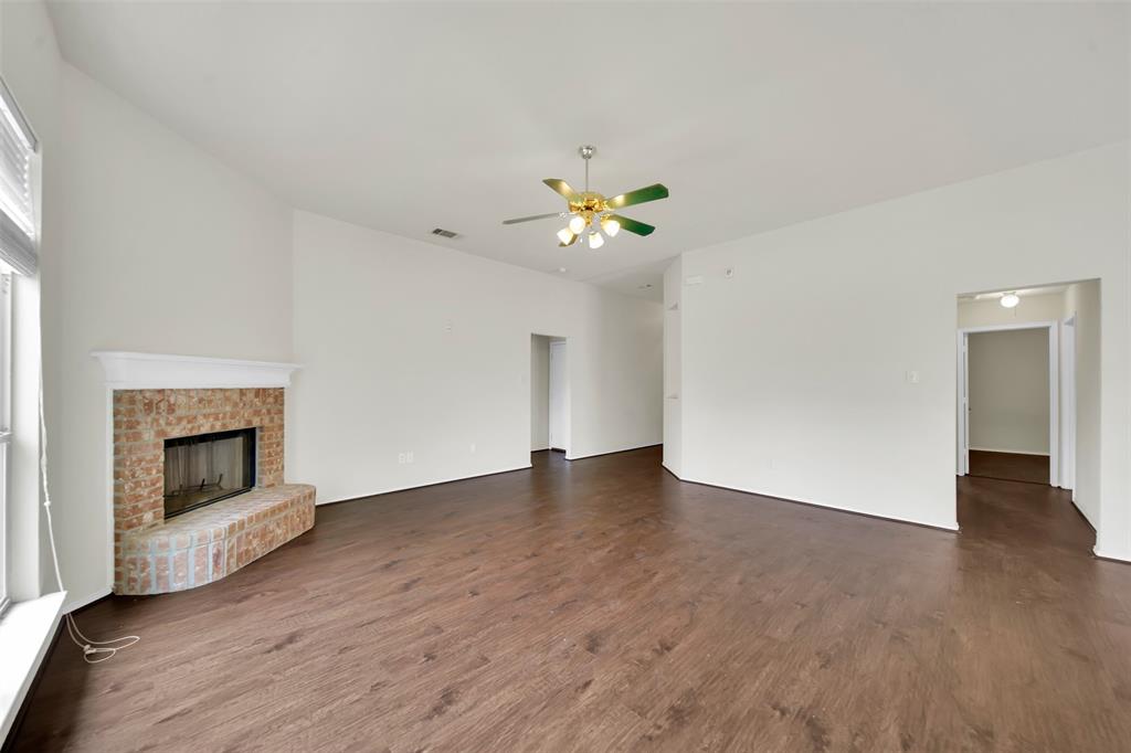 4221 Fiste Denton, TX 76207 - Photo 5 of 26 Unfurnished living room with ceiling fan, dark hardwood / wood-style floors, and a brick fireplace
