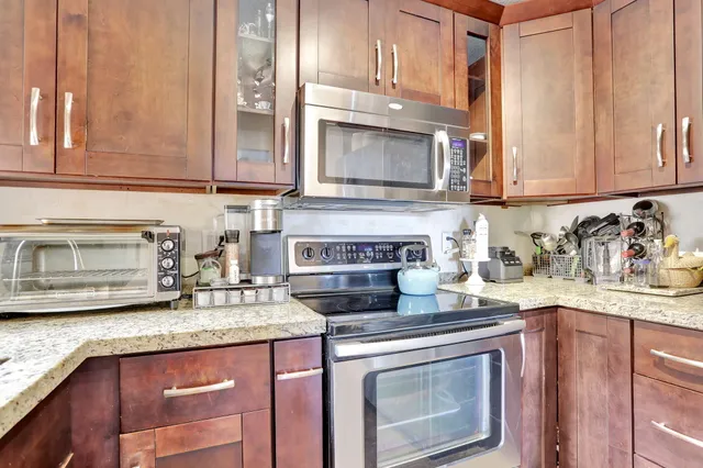 a kitchen with granite countertop a stove sink and cabinets