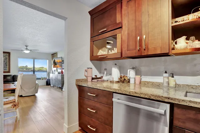 a kitchen with stainless steel appliances granite countertop a sink dishwasher stove and cabinets with wooden floor