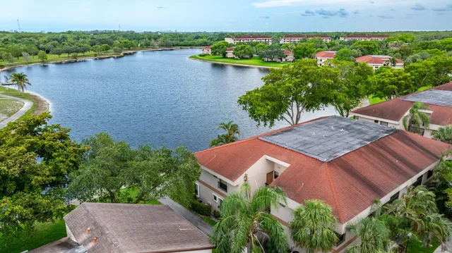 an aerial view of a house with garden space and lake view in back