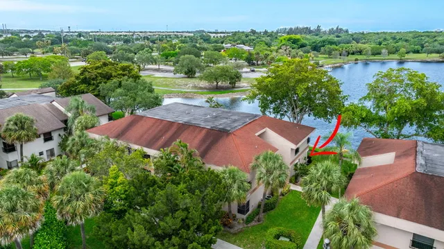 an aerial view of a house with a garden and lake view