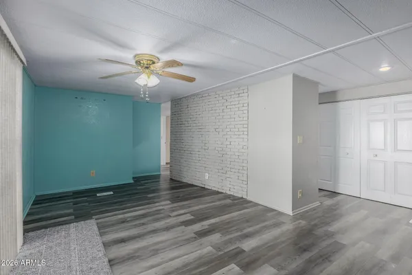 an empty room with closet and a chandelier fan