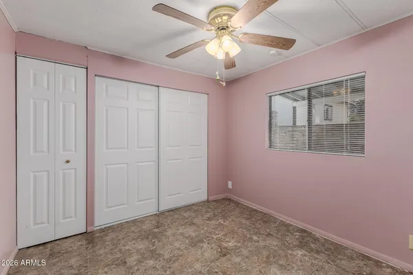 an empty room with windows and fan