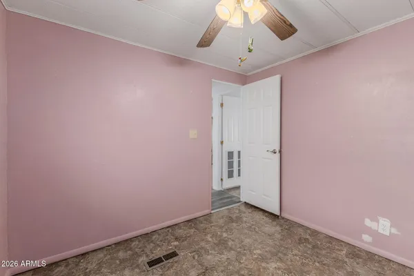 an empty room with a ceiling fan and painted walls