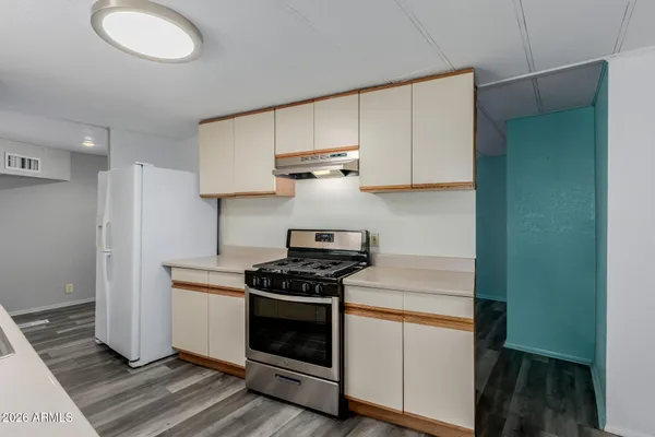 a kitchen with granite countertop wooden cabinets and a stove top oven