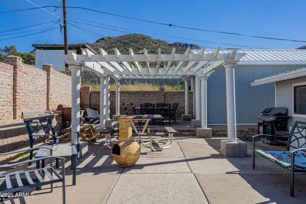 a view of a patio with dining table and chairs under an umbrella