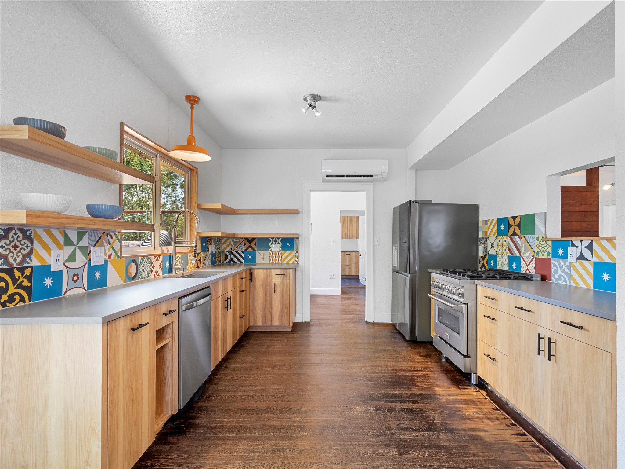 1809 Wilson Street Bastrop, TX 78602 - Photo 18 of 40 a kitchen with stainless steel appliances a stove top oven a refrigerator a sink and dishwasher with wooden floor