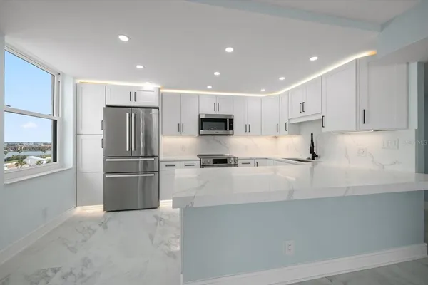 a kitchen with stainless steel appliances granite countertop a refrigerator and a stove top oven