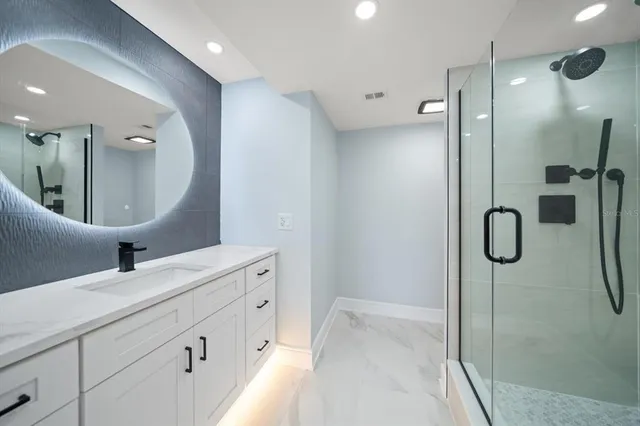 a bathroom with a double vanity sink mirror and shower