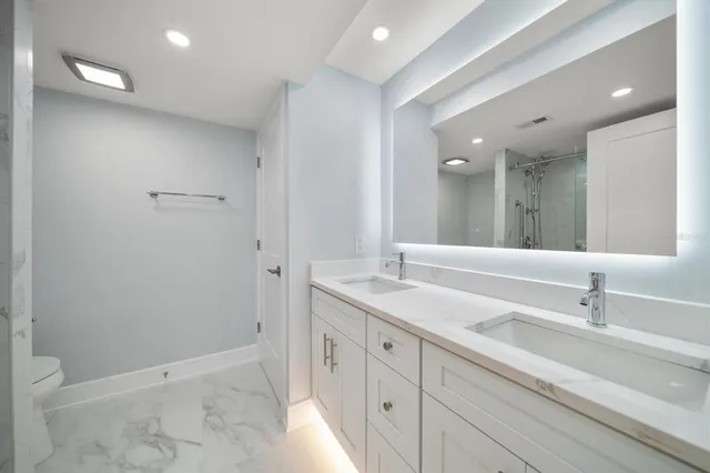 a bathroom with a double vanity sink and mirror