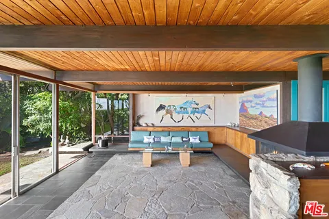 a living room with patio furniture and a garden