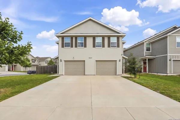 a front view of a house with a yard and garage