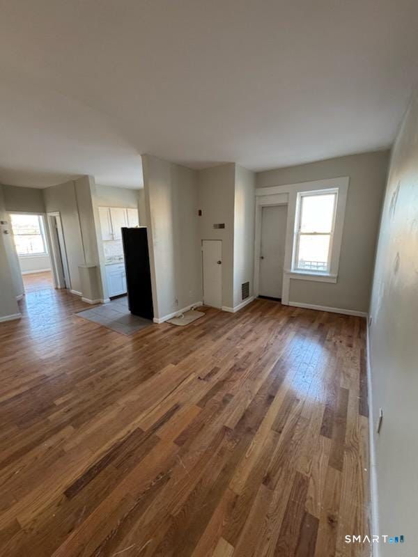 335 Wells Street, Unit 11 Bridgeport, CT 06606 - Photo 3 of 4 an empty room with wooden floor and windows