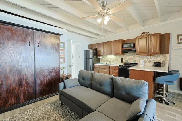 a living room with stainless steel appliances kitchen island granite countertop furniture and a view of kitchen