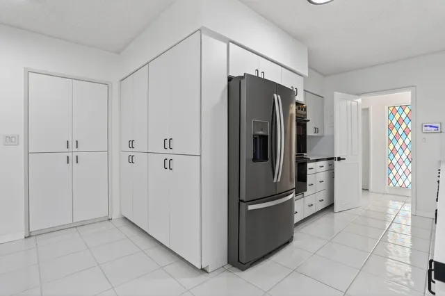 a kitchen with stainless steel appliances granite countertop a refrigerator and a sink