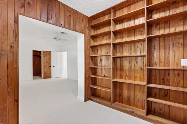 a view of an empty room with wooden shelves