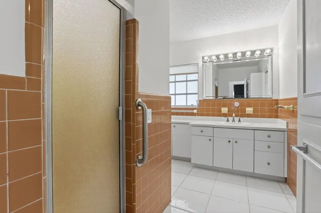 a bathroom with a granite countertop sink and a mirror