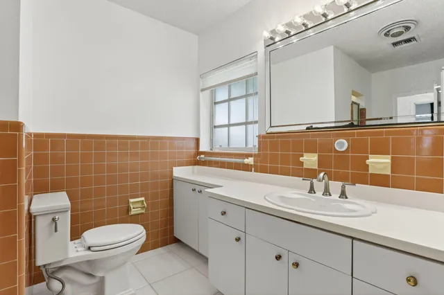 a bathroom with a sink a toilet and mirror