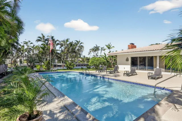 a view of a house with swimming pool and sitting area