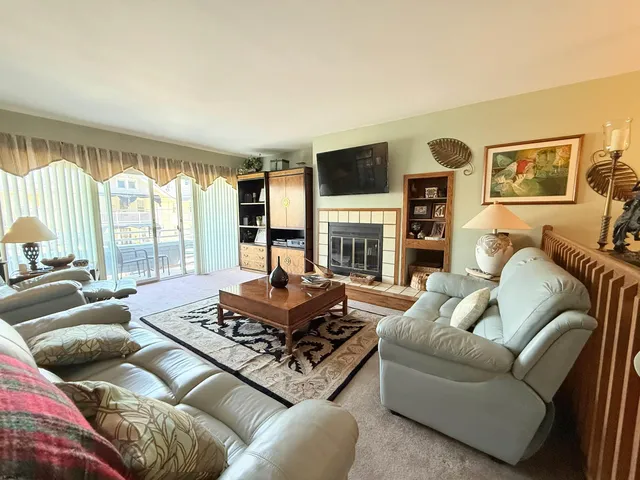 a living room with fireplace furniture and a large window