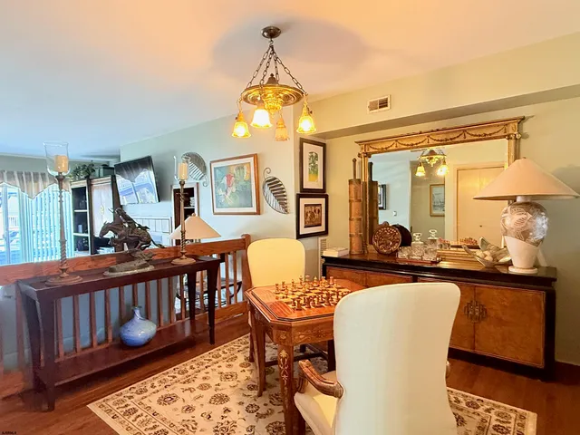 a dining room with wooden floor and large windows