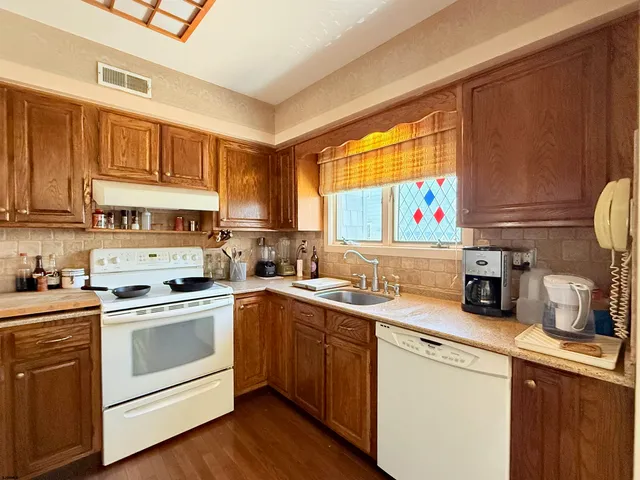 a kitchen with a sink cabinets and wooden floor