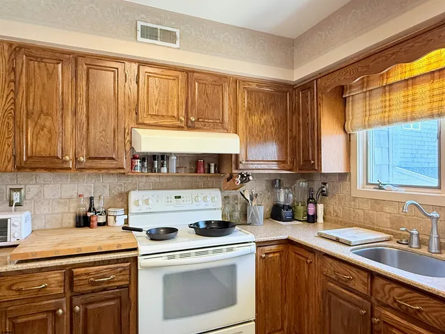 a kitchen with a stove a sink and cabinets