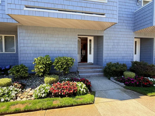 a front view of a house with a yard and outdoor seating