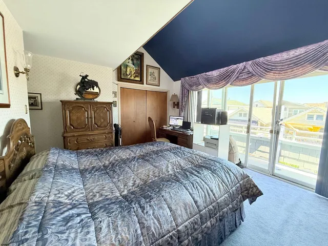 a bedroom with a bed and a large window with the outer view