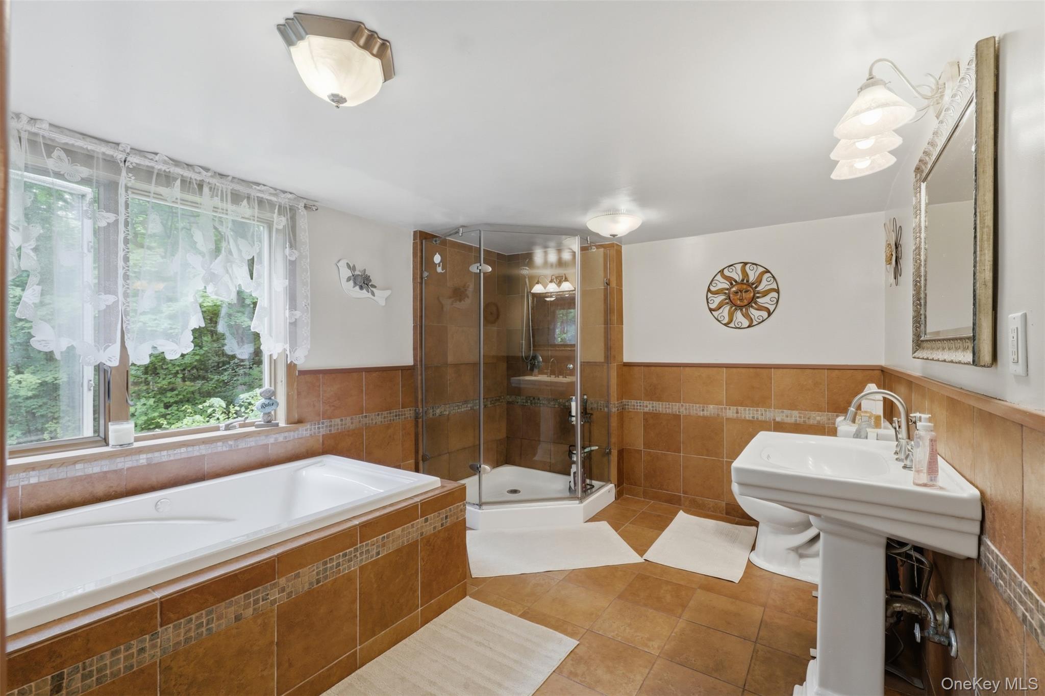 236 Hosner Mountain Road Hopewell Junction, NY 12533 - Photo 34 of 46 Bathroom featuring a built-in tub with tile surround, a corner glass-enclosed shower, and a pedestal sink