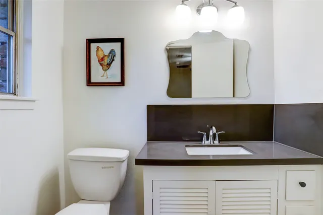 a bathroom with a toilet sink and mirror