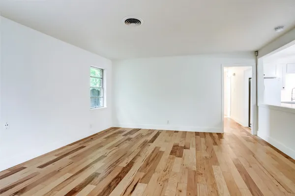 a view of room with window and wooden floor