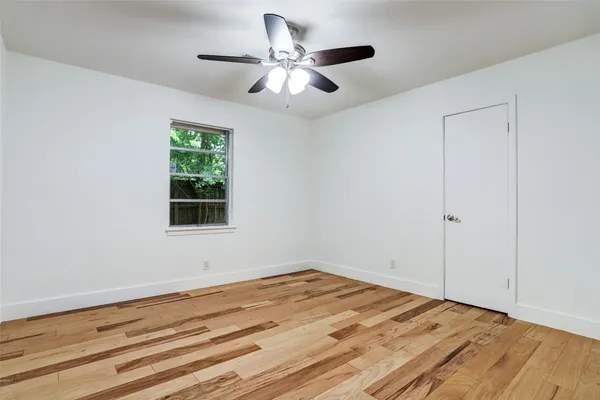 a view of a room with wooden floor and a window