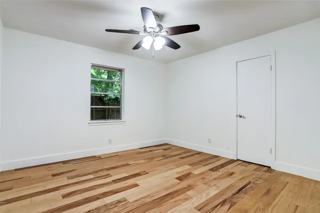 a view of a room with wooden floor and a window