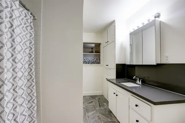 a kitchen with granite countertop white cabinets and stainless steel appliances